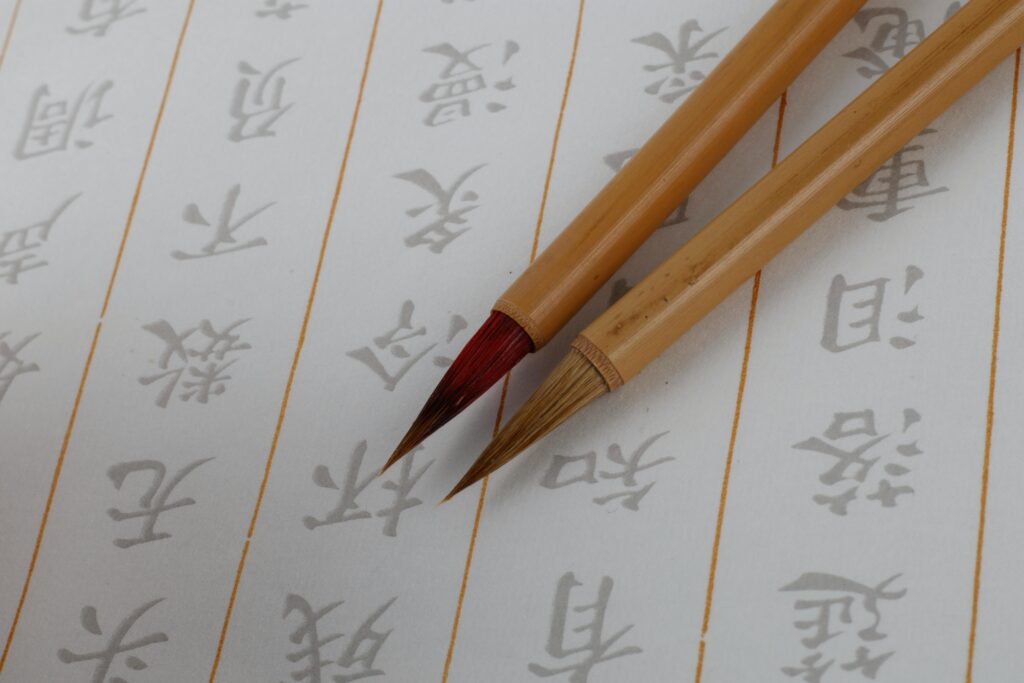 Close-up of Japanese calligraphy brushes on script paper, showcasing traditional artistry.